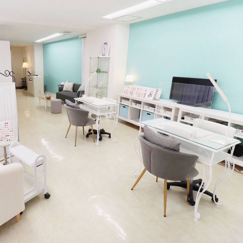 Ark nail & eyebeautyのネイルデスクと施術スペース。ティファニーブルーの壁とホワイトを基調とした明るく清潔感のある内観
